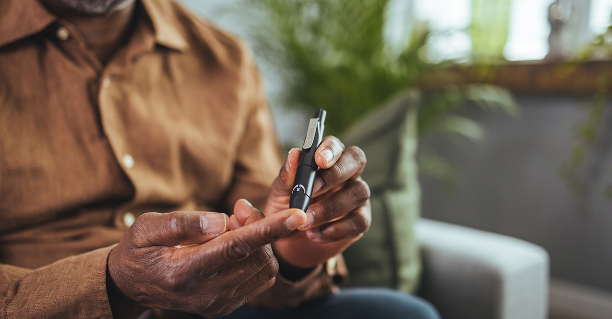 African American senior checking his blood sugar with his glucometer due to diabetes.