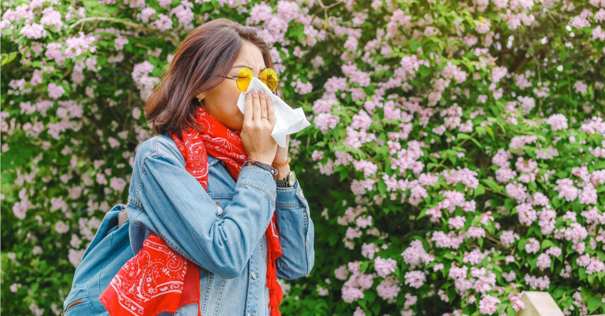 Woman blowing nose into napkin