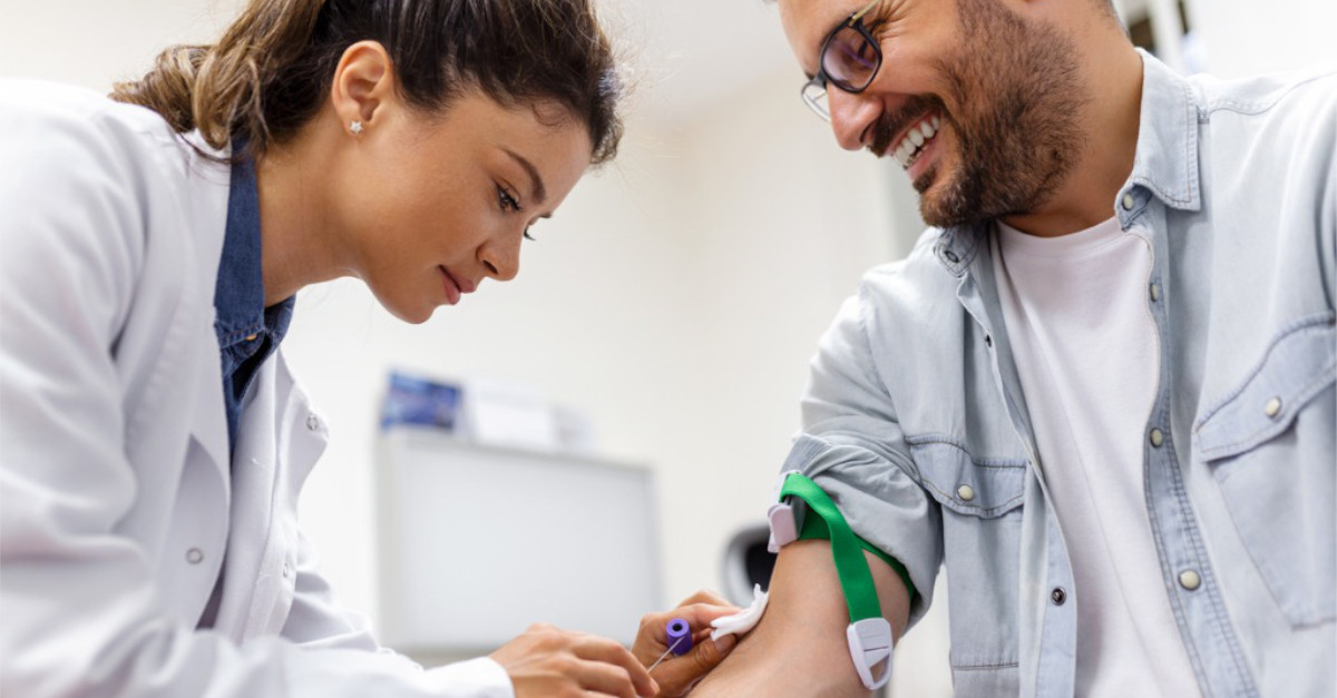 Doctor taking blood from patient